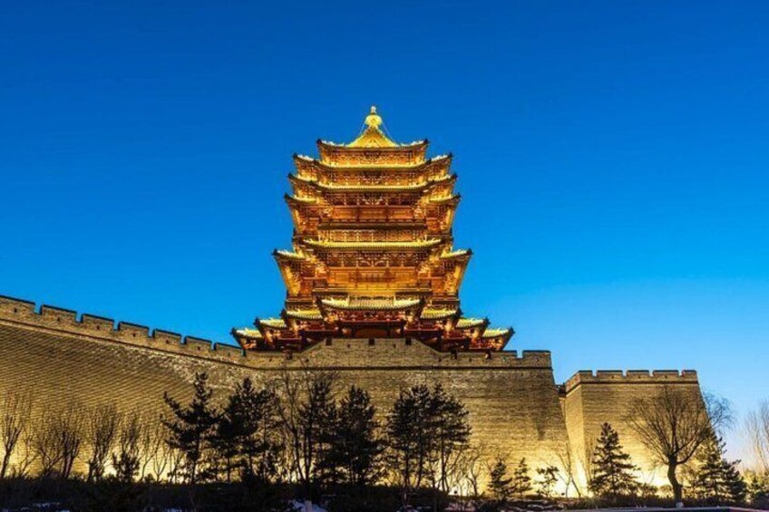 A multi-tiered pagoda with a golden roof, surrounded by a stone wall and trees. 4
