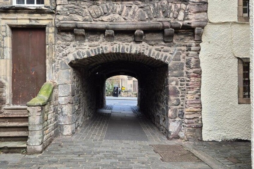 A stone archway leading into a street. 5