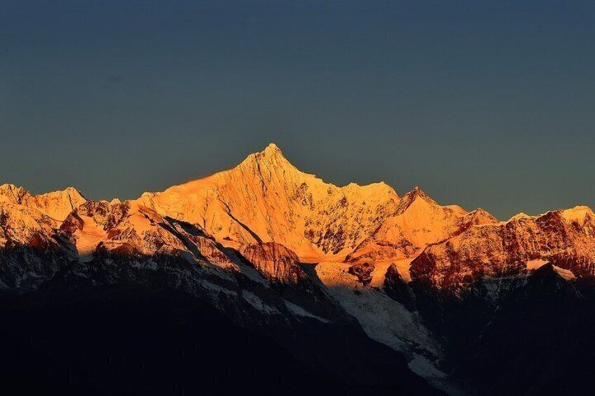 A mountain range with snow-capped peaks bathed in golden sunlight. 5