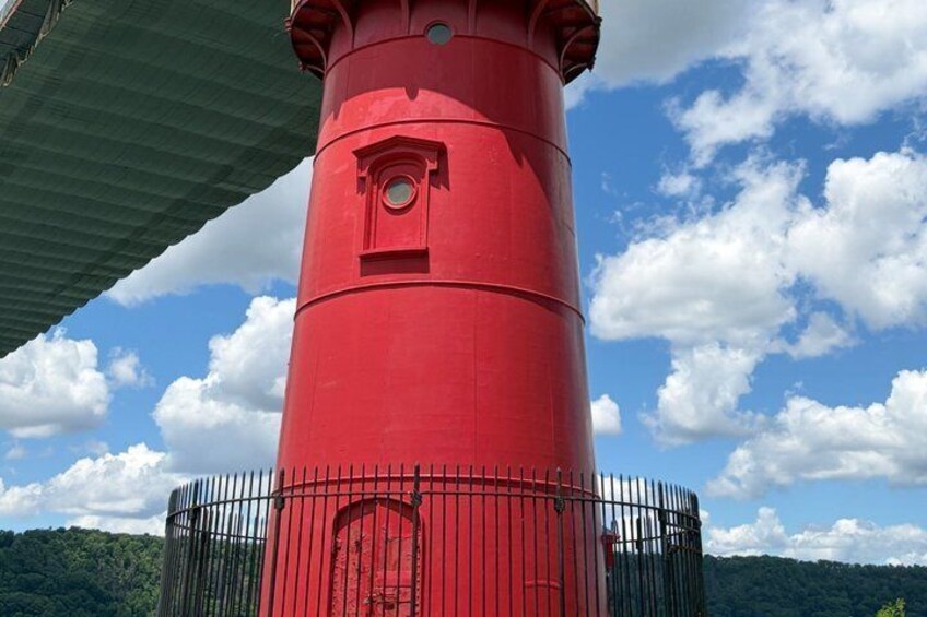 A red lighthouse with a circular window and a metal fence. 3