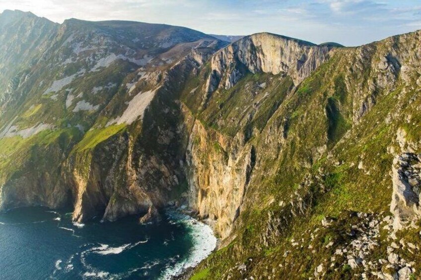 A mountainous landscape with steep cliffs and a coastline. 2