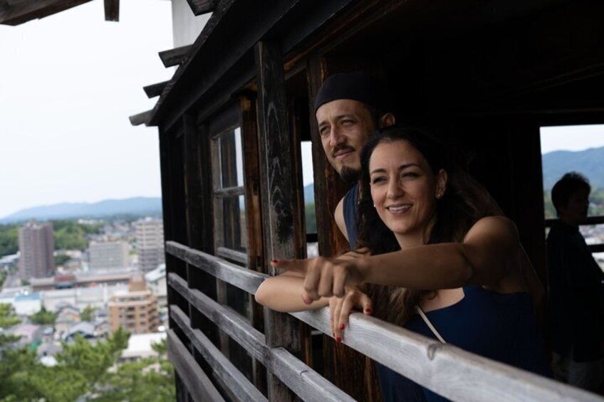 A wooden balcony with a cityscape view. 2