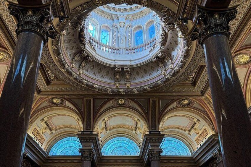 An ornate interior with a domed ceiling, columns, and arched windows. 5
