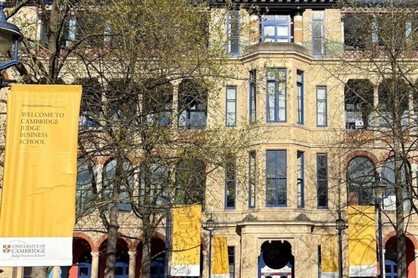 A historic building with a prominent entrance and a banner reading 'Welcome to Cambridge Judge Business School.' 3