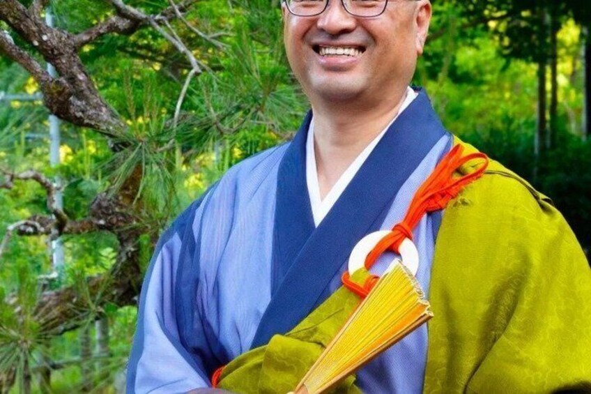 A person in traditional attire holding a book. 5