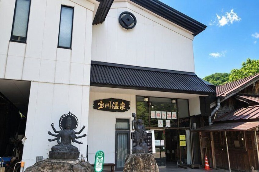 A building with a sign that reads '宝川温泉' (Bakawa Onsen). 4