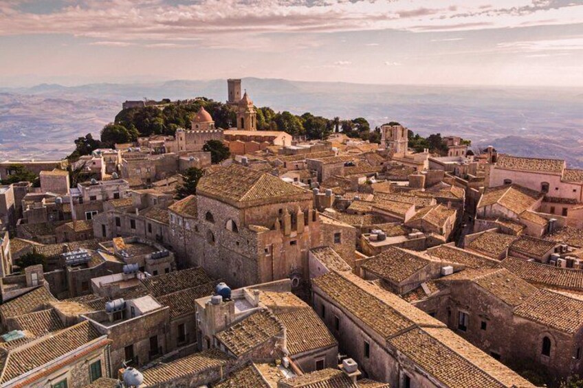 A historic town with medieval architecture, including a prominent church and fortress on a hill. 3