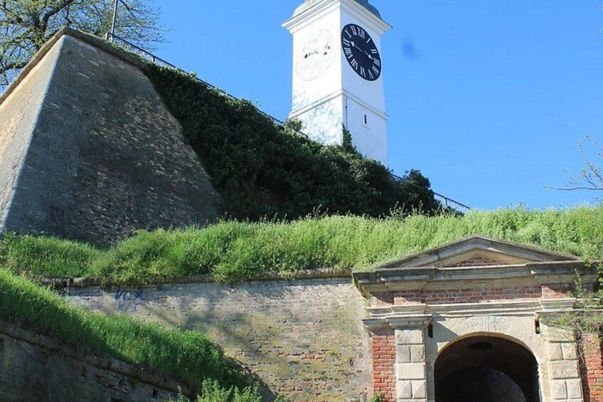 A clock tower, a stone wall, and a brick archway. 2
