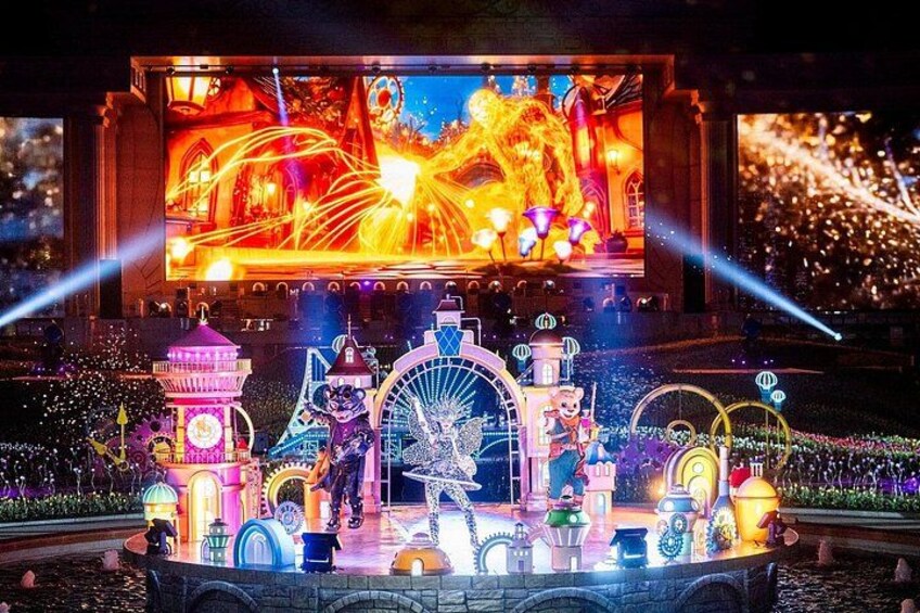 A nighttime amusement park with illuminated rides and structures. 2