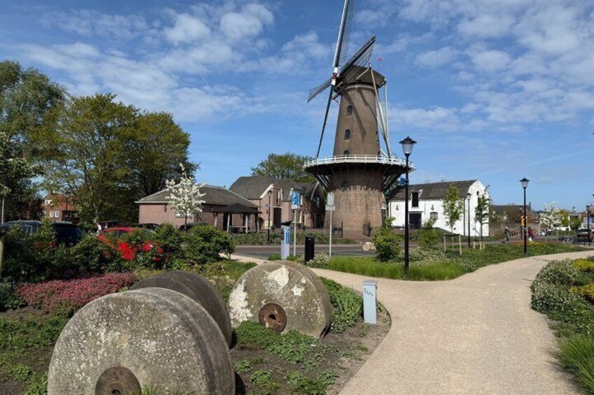 A windmill, a pathway, and a building with a white facade. 1