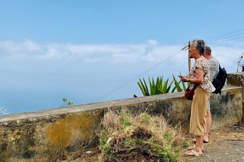 Two people standing on a concrete ledge overlooking the ocean. 3