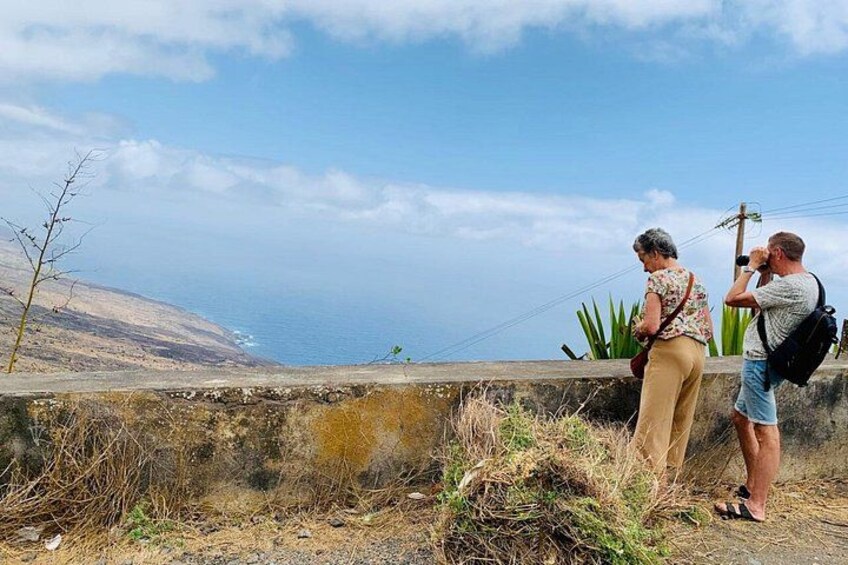 Two people taking a photo, a coastal landscape with a clear sky, and a distant view of the sea. 2