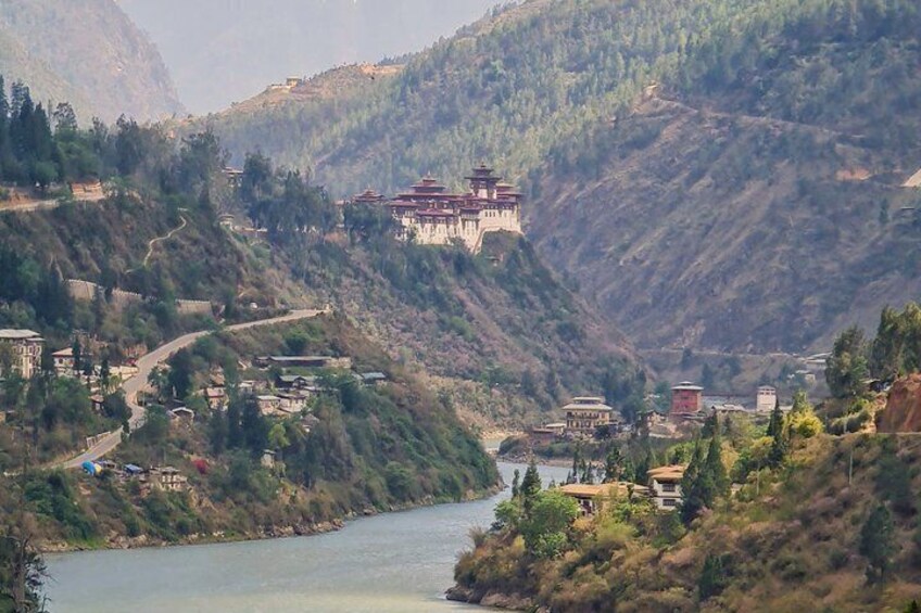 A mountainous landscape with a river, a monastery, and a winding road. 3