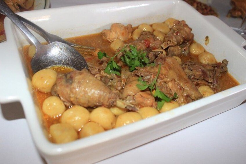 A dish with meat, potatoes, and a garnish. 4