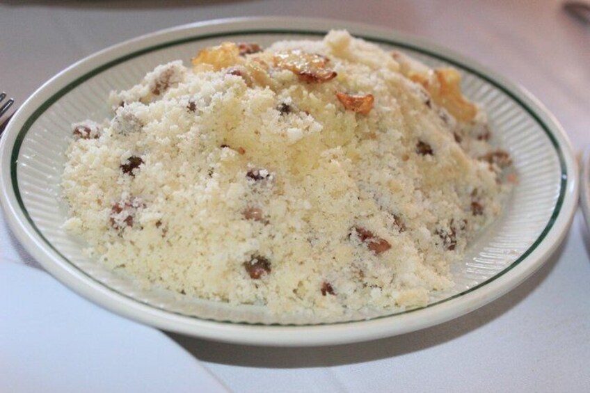 A plate of couscous with raisins and nuts. 1