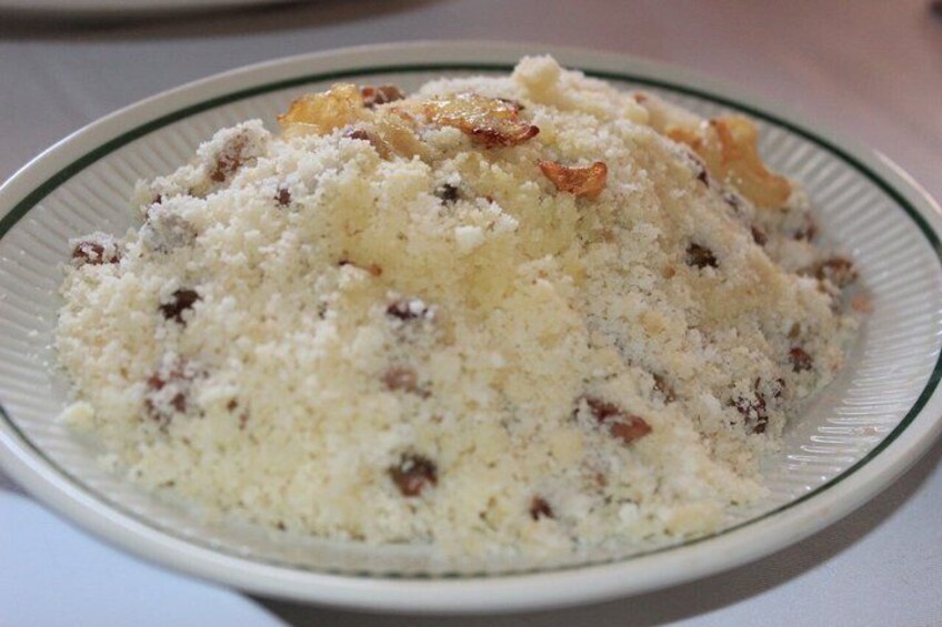 A plate of food with a crumbly texture and visible nuts. 3