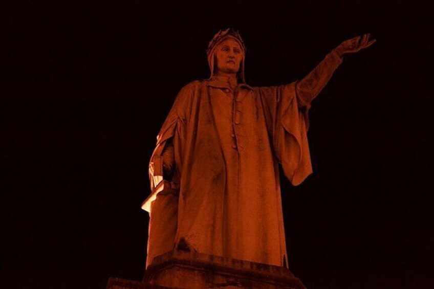A statue with outstretched arms, wearing a robe, and illuminated by a spotlight. 5