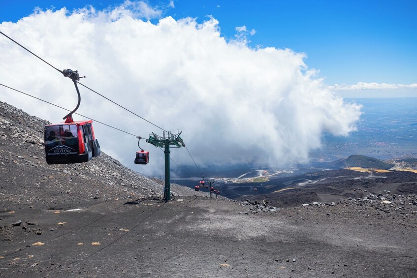 A cable car system on a mountain with a view of a valley below. 4