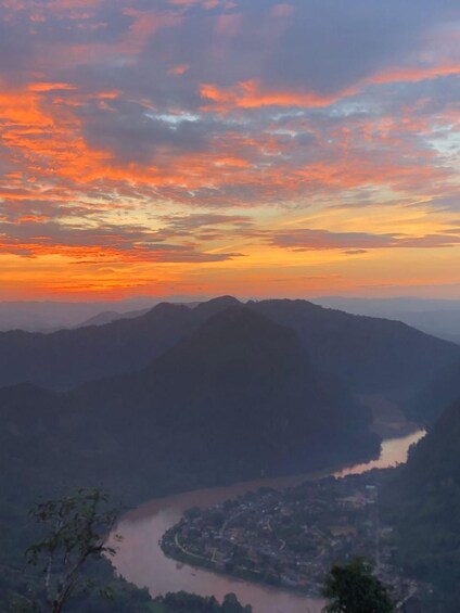 A river winding through a valley with mountains in the background and a sunset sky. 3