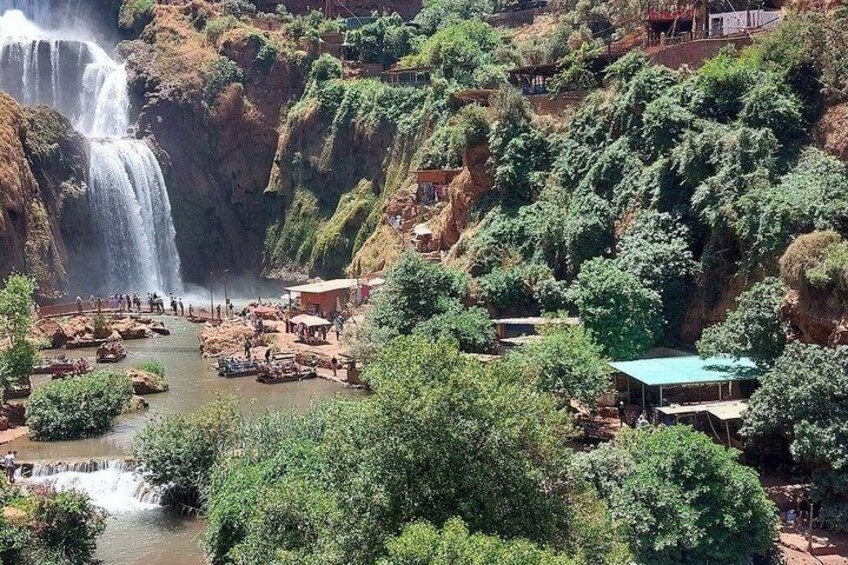 A waterfall, a river, and a village with buildings and boats. 3