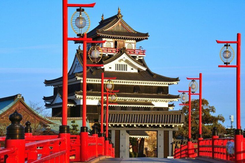 A traditional Japanese building with a multi-tiered roof, red lanterns, and a gate. 1