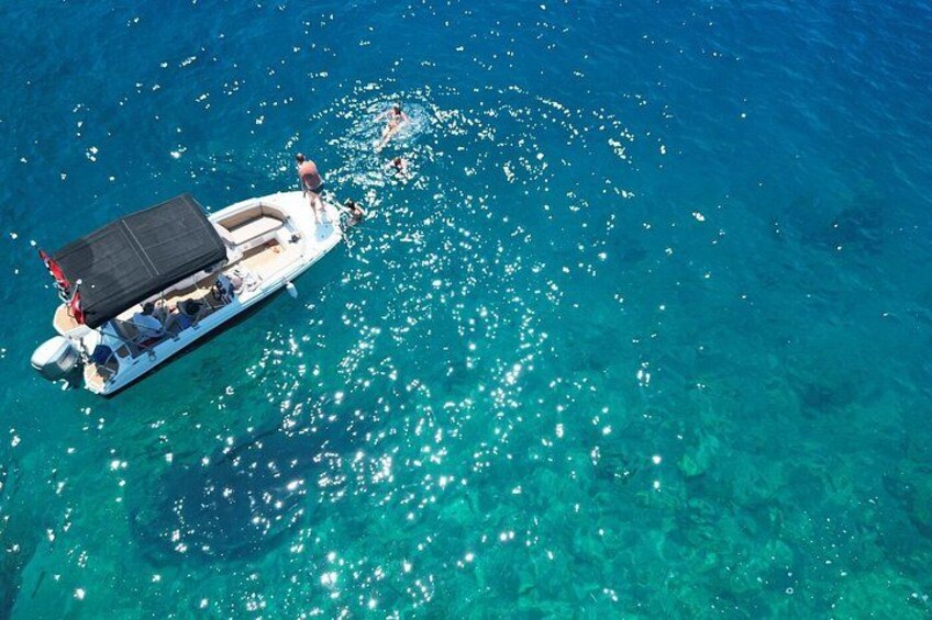 Ein Boot mit Personen auf ruhigem, blauem Meer. 2