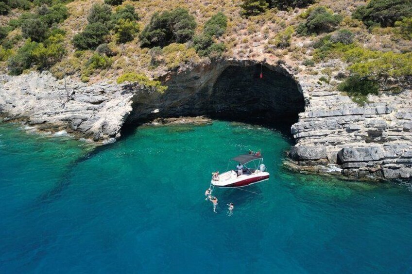 A boat anchored near a rocky cove with clear turquoise water. 5