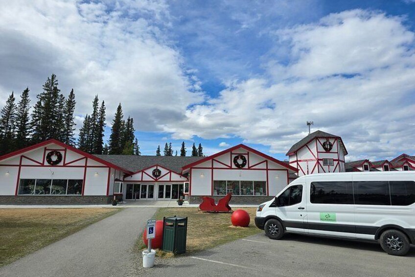 A building with red trim and a large sign, a white van parked in front, and a red ball on the ground. 3