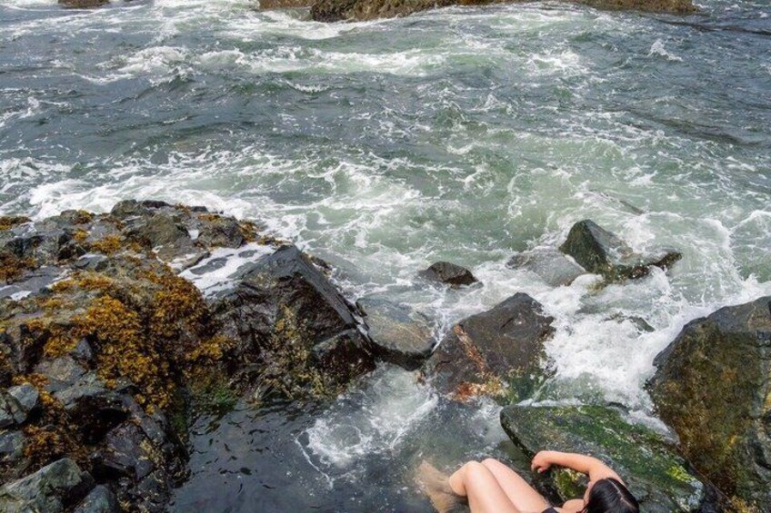 A person sitting on rocks by a turbulent river. 2
