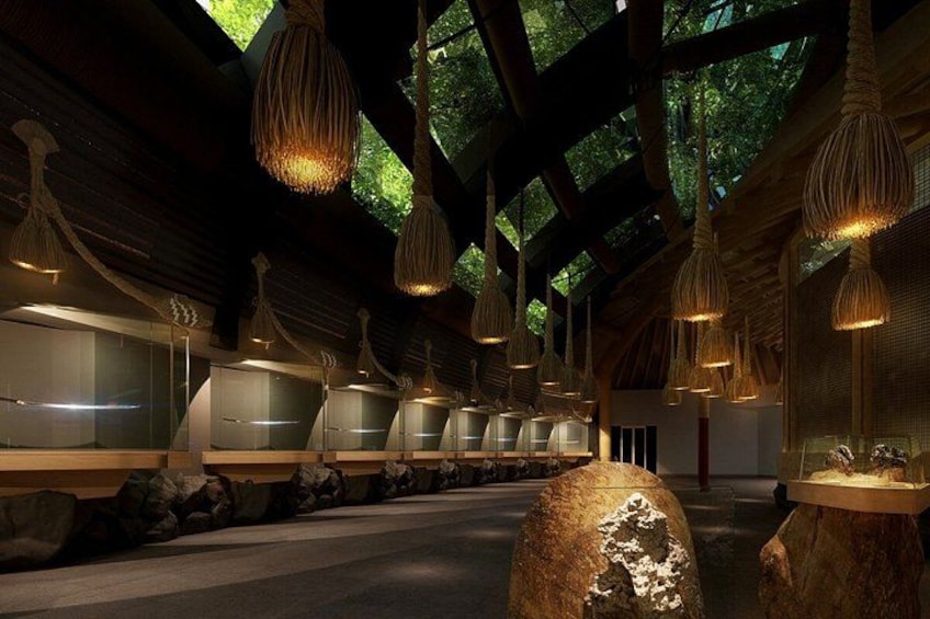 A restaurant interior with hanging lights, wooden beams, and a stone centerpiece. 5