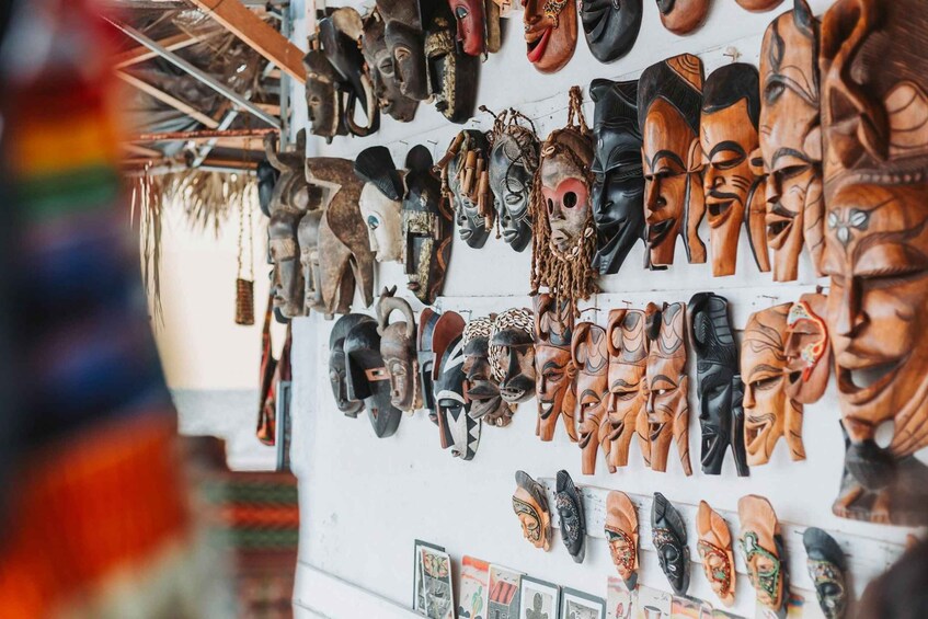 A variety of wooden masks hanging on a wall. 5