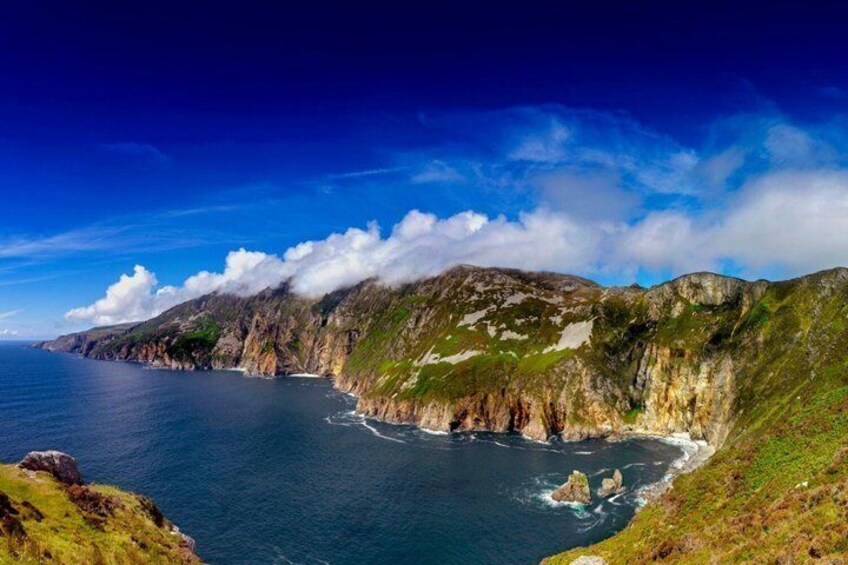 A coastal landscape with cliffs, ocean, and a clear sky. 3