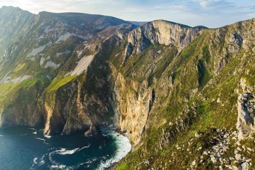 A mountainous landscape with steep cliffs and a coastline. 4