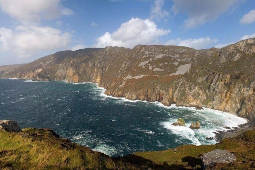 A rugged coastline with steep cliffs and a turbulent sea. 2