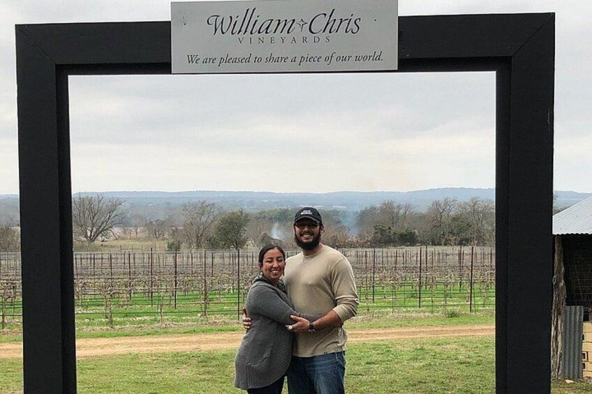 A framed photo of two people with a vineyard in the background. 1