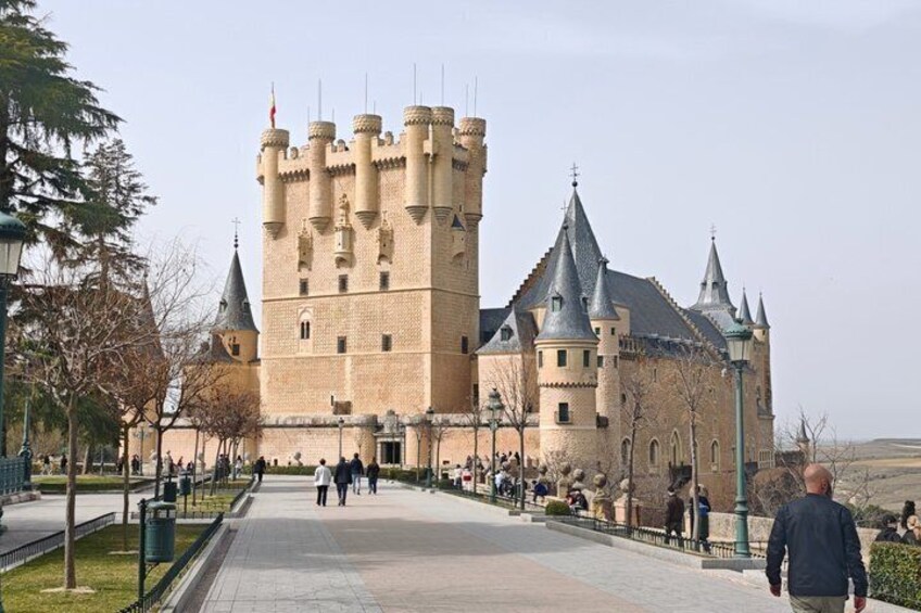 A castle with multiple towers and a paved walkway. 1