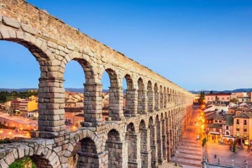 An ancient aqueduct with multiple arches spanning a city street. 3