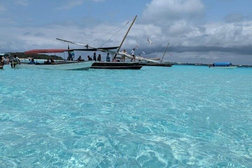 A clear turquoise sea with boats and people. 2