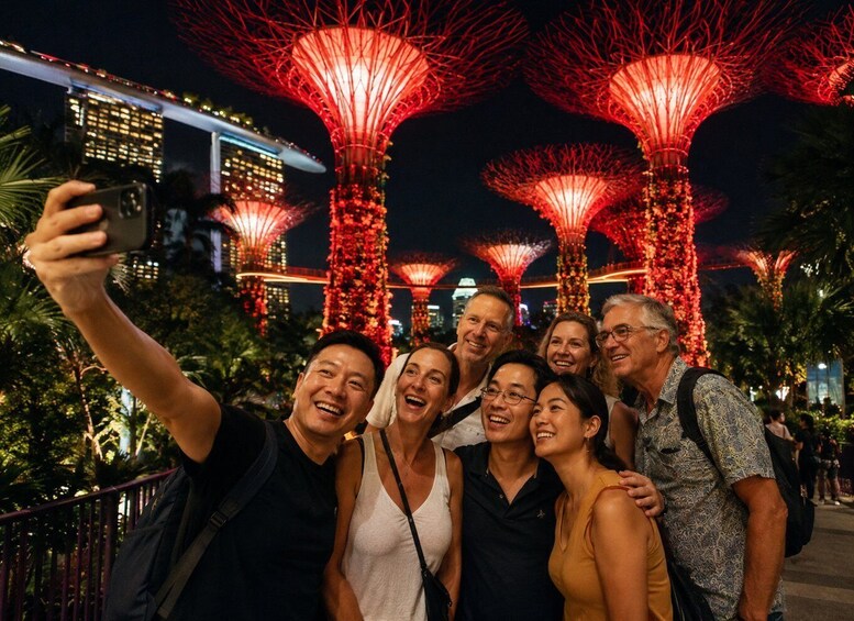 A group of people taking a selfie with the Suoi Tien Towers illuminated in red. 1