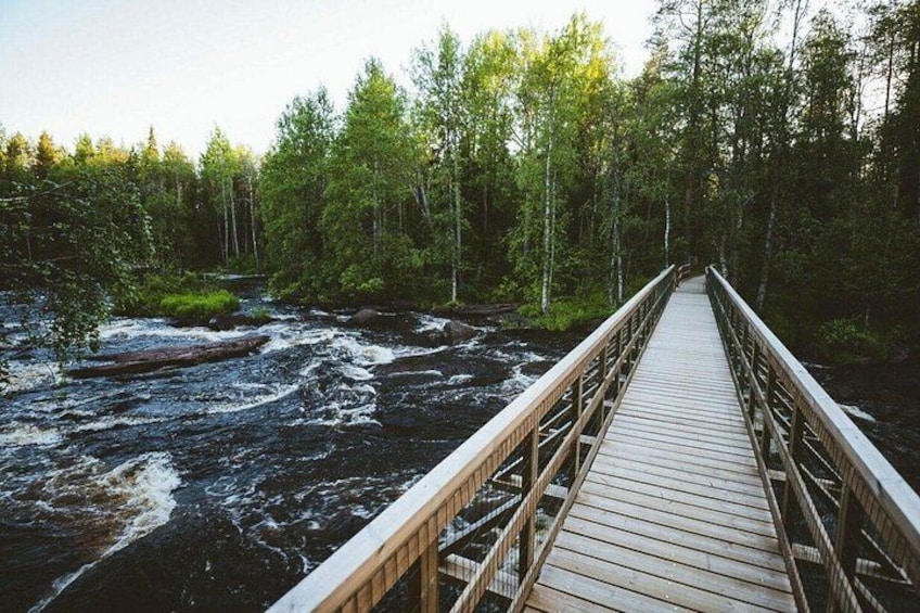 A wooden bridge over a river with a forested area on either side. 1