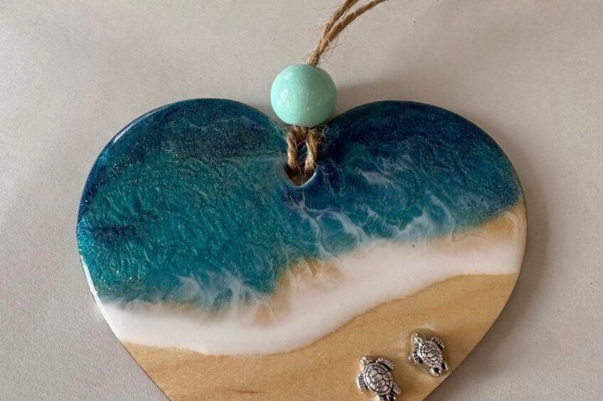 A heart-shaped decorative item with a beach scene, a turquoise bead, and two turtle-shaped charms. 3