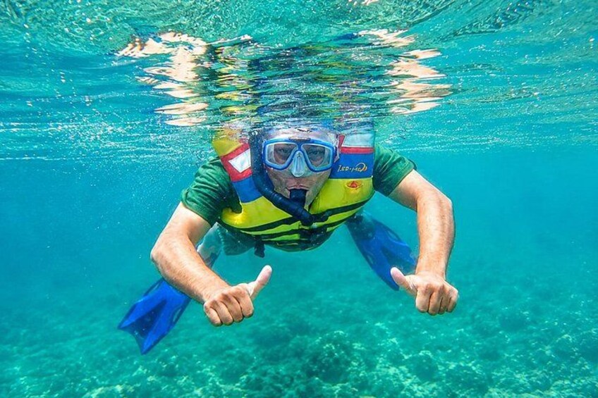 A person underwater, wearing a snorkel and fins, with a clear view of the ocean floor. 5
