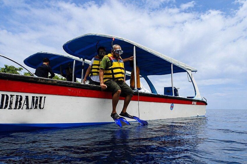 A boat named 'DIBAMU' with people wearing life jackets and a snorkel. 4