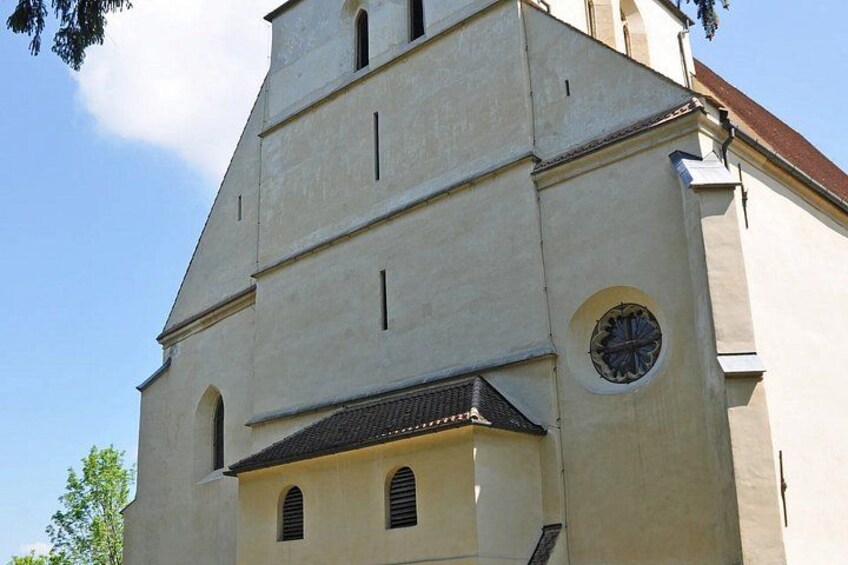 A church with a bell tower, a clock, and a tiled roof. 4
