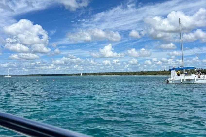 A sailboat on a calm sea with a clear sky and distant land. 3
