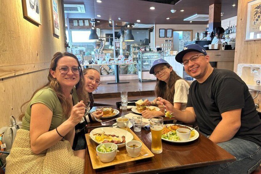 A group of people dining at a restaurant with wooden interiors and a counter visible in the background. 5