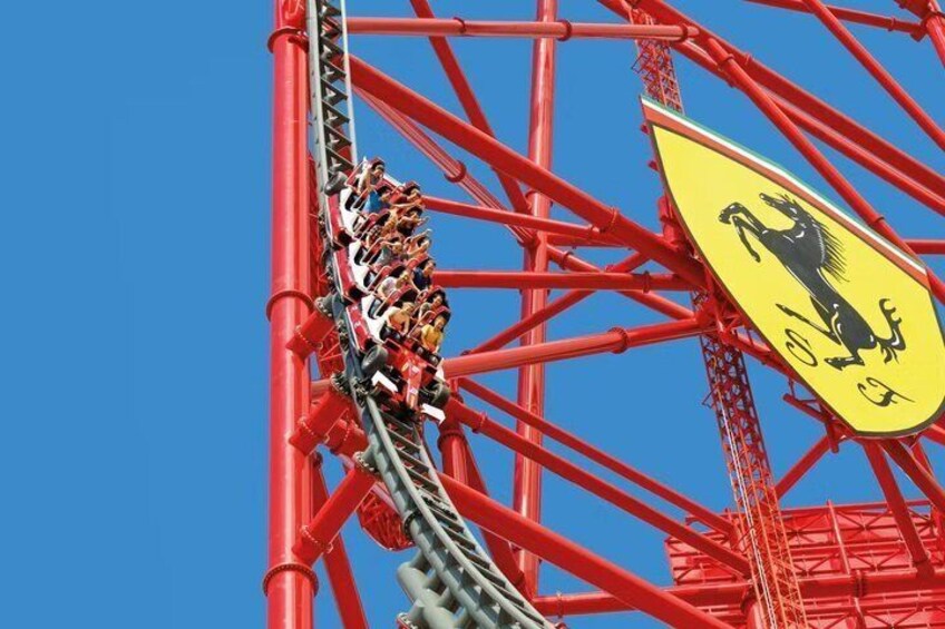 A roller coaster with riders in a loop against a clear blue sky. 2