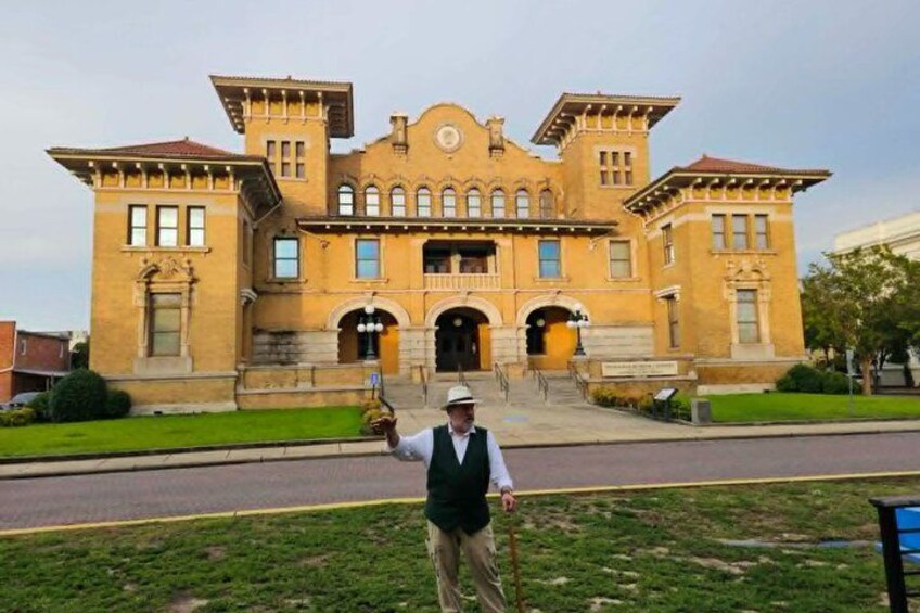 A historic building with a symmetrical facade, arched windows, and a central entrance. 4
