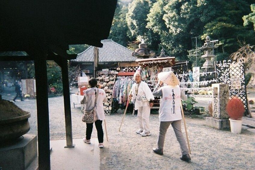 A traditional Japanese shrine with a stone lantern, a wooden structure, and a shrine gate. 3
