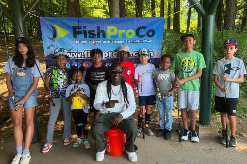 A group of people posing in front of a banner for FishProCo. 1